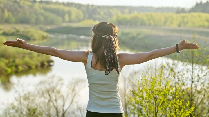 Healing Space vrouw met gestrerkte armen bij water